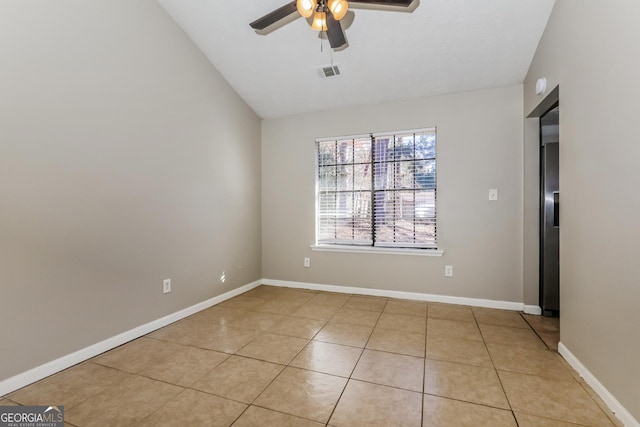 spare room with ceiling fan, light tile patterned floors, and vaulted ceiling