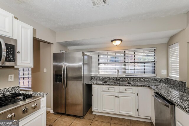 kitchen with sink, white cabinetry, stainless steel appliances, and light tile patterned floors