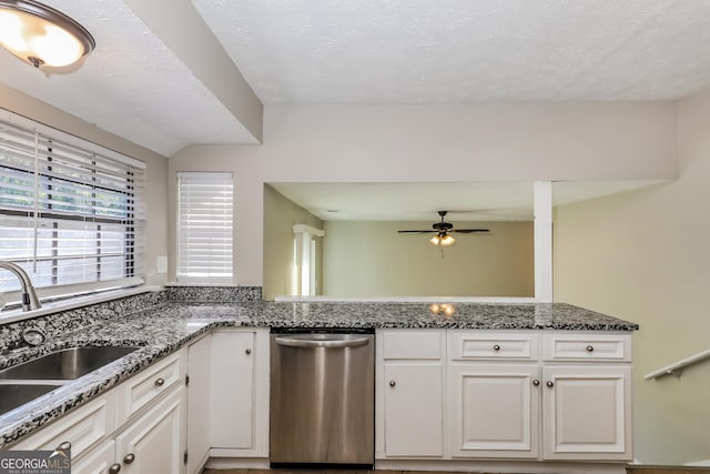 kitchen featuring ceiling fan, dishwasher, sink, dark stone counters, and white cabinets