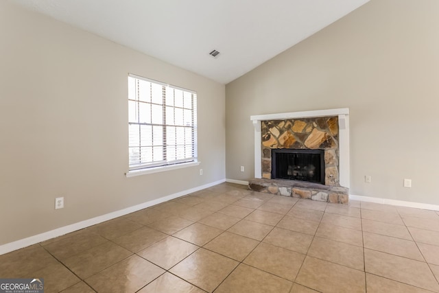 unfurnished living room featuring a fireplace, light tile patterned floors, and lofted ceiling