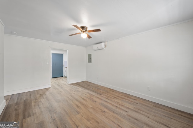 empty room featuring an AC wall unit, ornamental molding, electric panel, and light hardwood / wood-style flooring