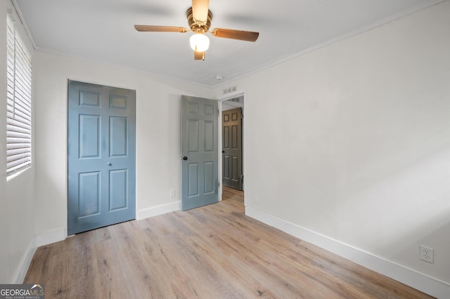unfurnished bedroom featuring ceiling fan, a closet, light wood-type flooring, and ornamental molding