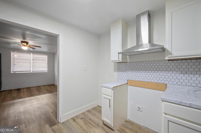 kitchen with white cabinets, decorative backsplash, and wall chimney range hood