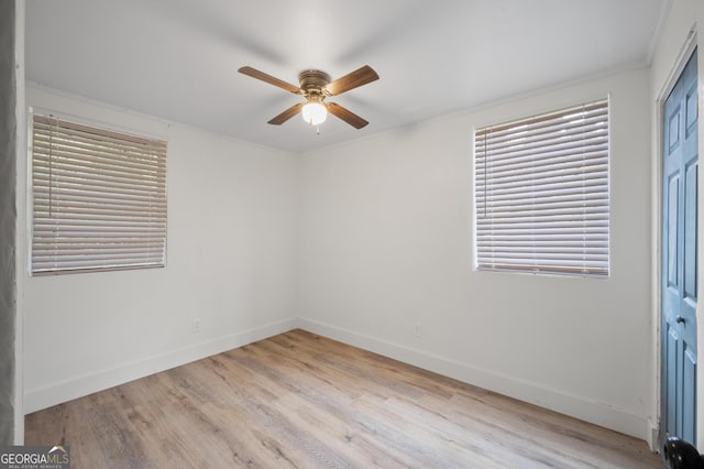 spare room with ceiling fan, light wood-type flooring, and crown molding