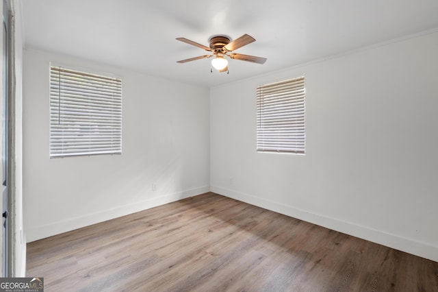 spare room featuring light wood-type flooring, ceiling fan, and ornamental molding