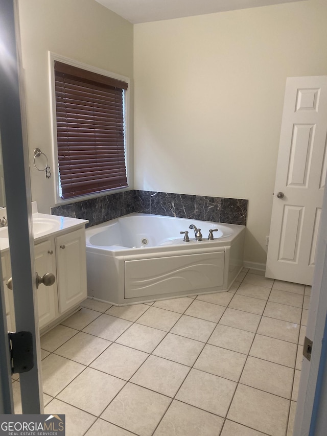 bathroom featuring tile patterned flooring, vanity, and a washtub