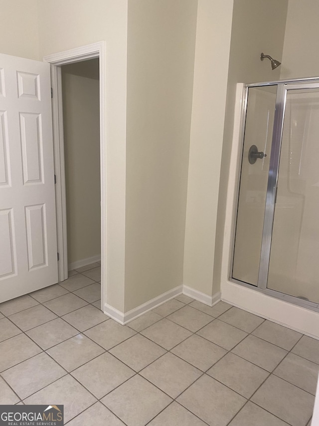 bathroom with tile patterned floors and a shower with shower door