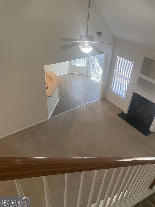 staircase featuring ceiling fan and high vaulted ceiling