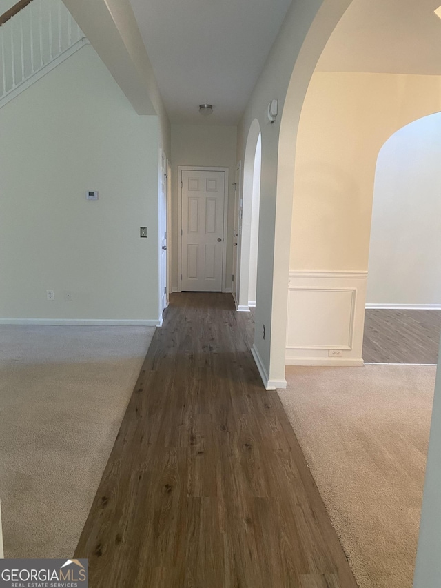 hall with dark colored carpet