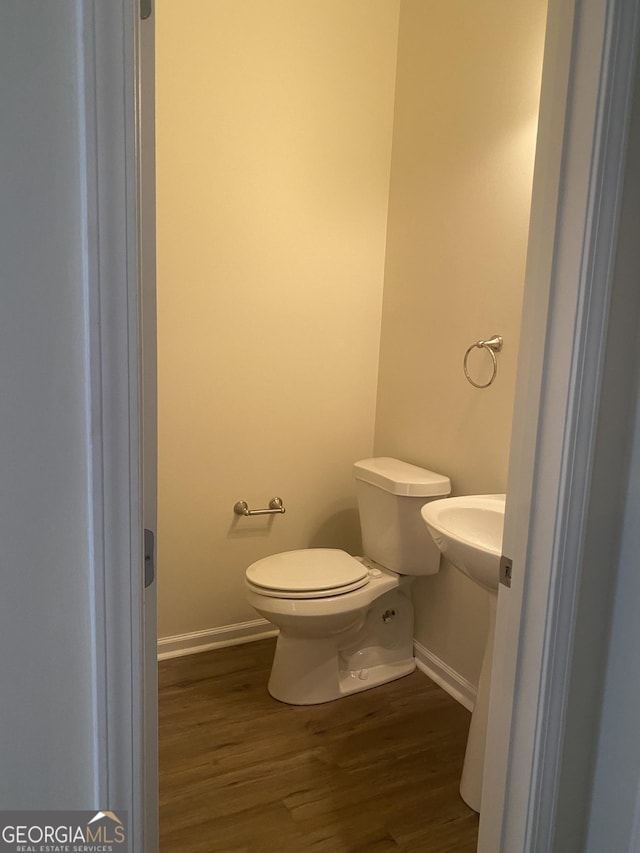 bathroom featuring wood-type flooring and toilet