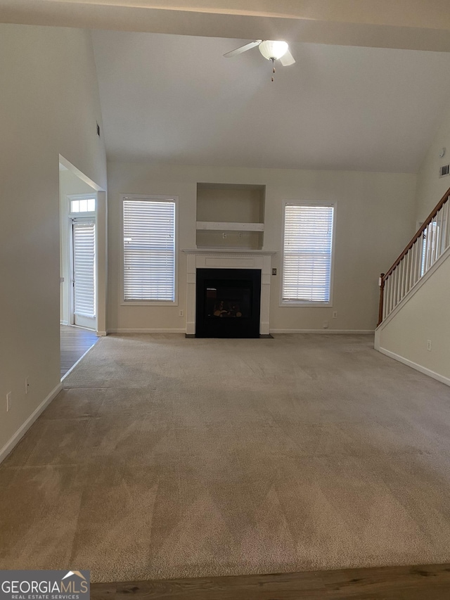 unfurnished living room with ceiling fan, light carpet, and vaulted ceiling