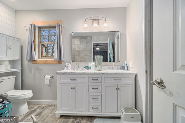 bathroom with hardwood / wood-style floors, vanity, and toilet