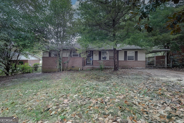 ranch-style house with a carport and a front lawn