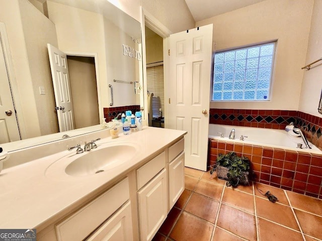 bathroom featuring vanity, a relaxing tiled tub, and tile patterned floors