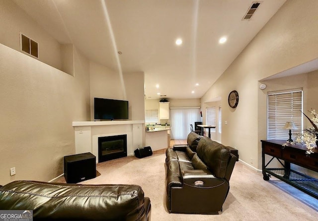 carpeted living room featuring high vaulted ceiling