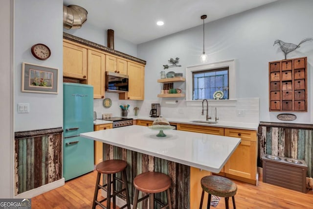 kitchen featuring pendant lighting, a kitchen bar, sink, and stainless steel appliances