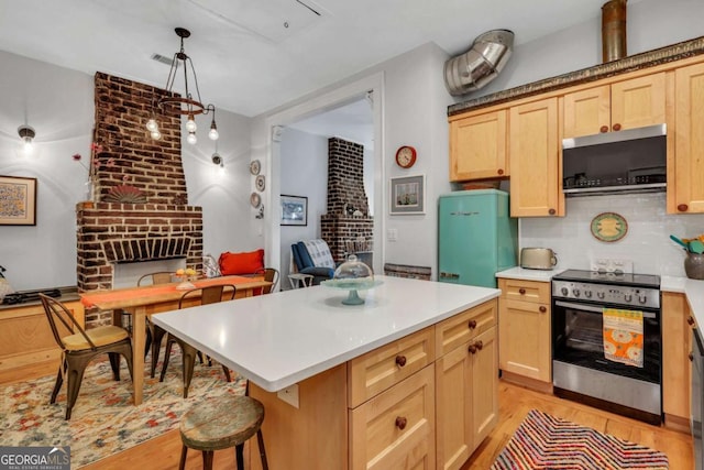 kitchen featuring stainless steel electric range, hanging light fixtures, light brown cabinetry, a kitchen island, and a breakfast bar area