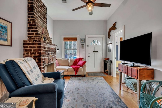 living room with ceiling fan and light wood-type flooring