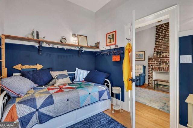 bedroom featuring a fireplace and hardwood / wood-style floors