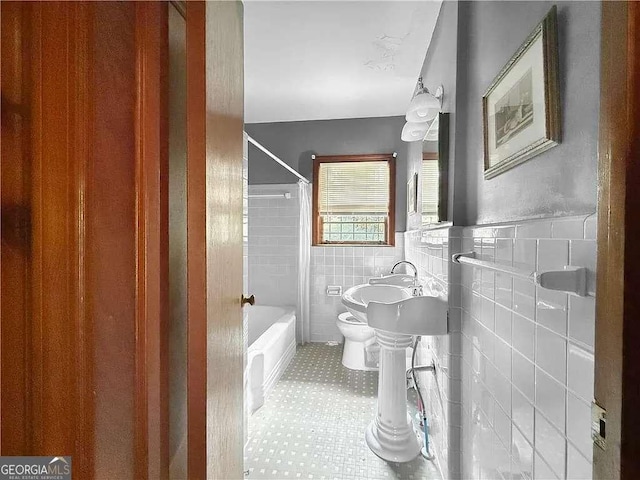 full bathroom featuring sink, shower / bath combo, tile walls, and toilet