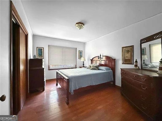 bedroom with dark hardwood / wood-style floors