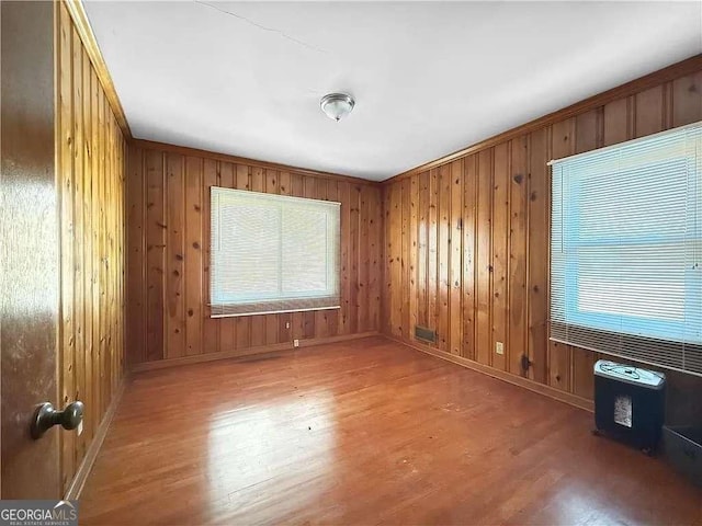 spare room with wooden walls and hardwood / wood-style floors