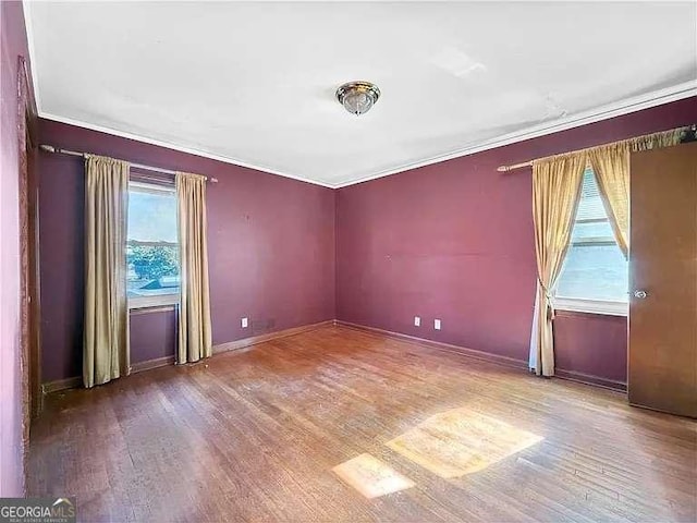 unfurnished room featuring hardwood / wood-style floors and crown molding