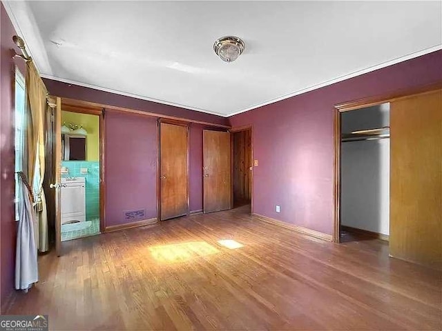 unfurnished bedroom featuring crown molding and light hardwood / wood-style flooring