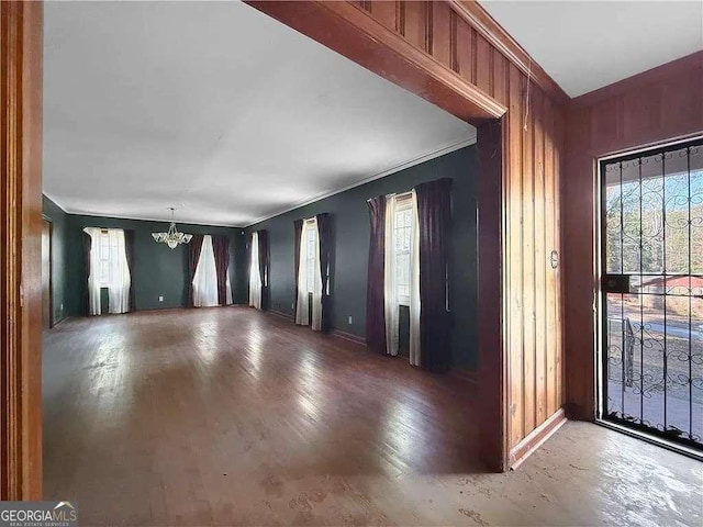 foyer with a notable chandelier, crown molding, and a wealth of natural light