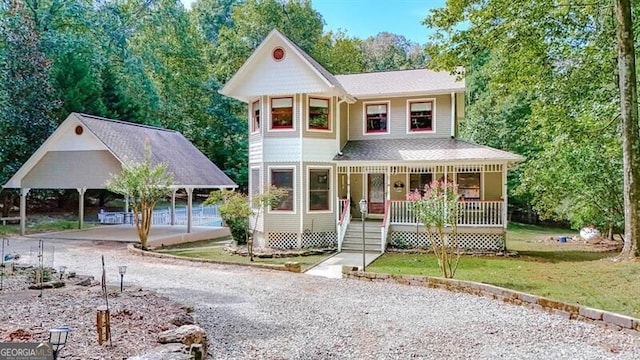 view of front facade with a carport, covered porch, and a front lawn