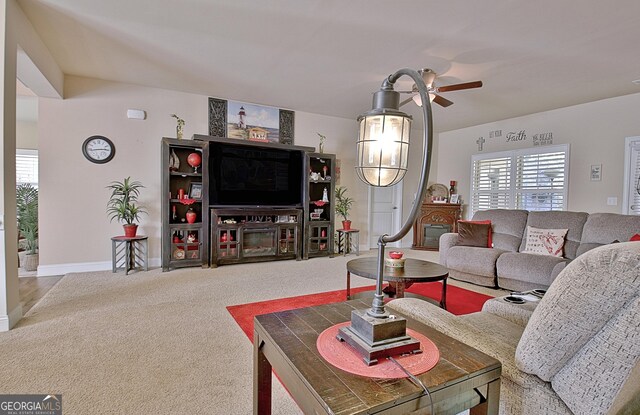 carpeted living room featuring plenty of natural light and ceiling fan