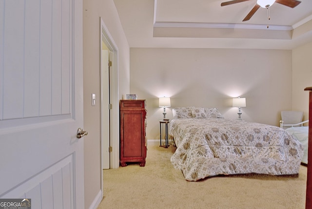 bedroom with ceiling fan, ornamental molding, carpet flooring, and a raised ceiling