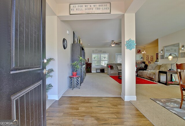 foyer featuring light carpet and ceiling fan