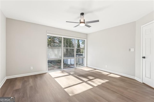 unfurnished room with ceiling fan and dark hardwood / wood-style flooring