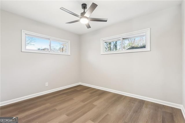 spare room with ceiling fan, plenty of natural light, and hardwood / wood-style flooring