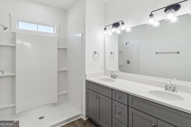 bathroom featuring hardwood / wood-style flooring, vanity, and a shower