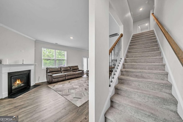 staircase featuring hardwood / wood-style floors and ornamental molding