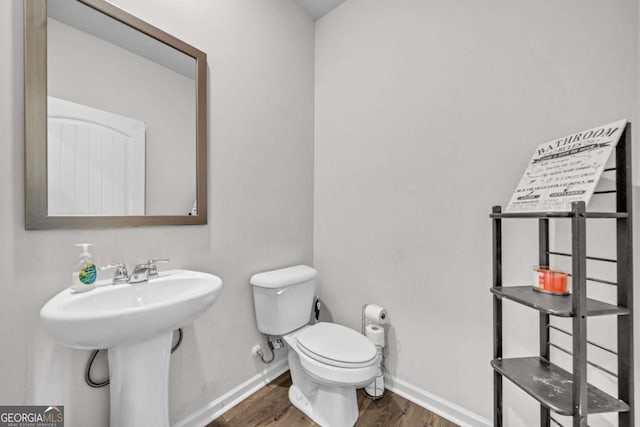 bathroom with hardwood / wood-style flooring, toilet, and sink