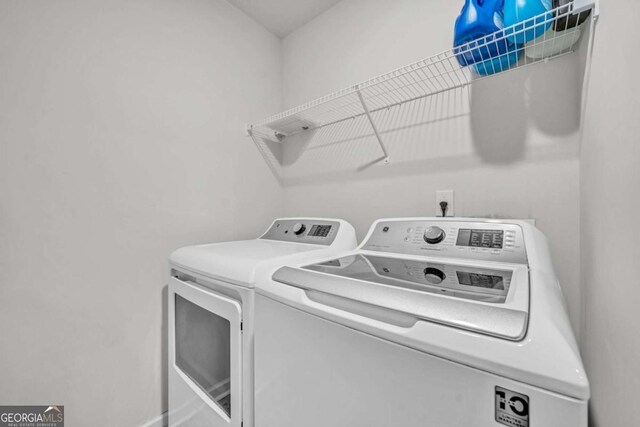 clothes washing area with washer and clothes dryer