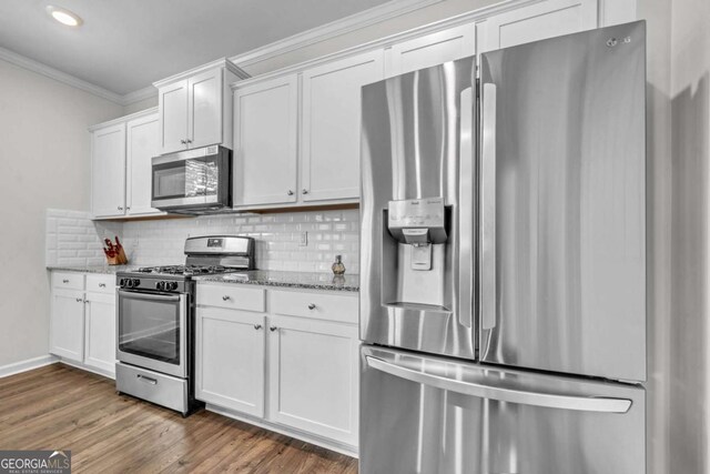 kitchen featuring backsplash, light stone countertops, white cabinetry, and stainless steel appliances