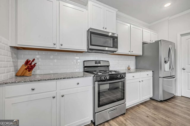 kitchen featuring backsplash, crown molding, white cabinetry, and stainless steel appliances