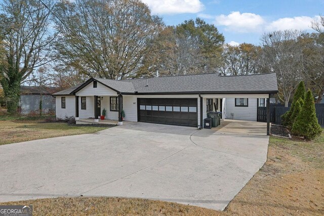 ranch-style house featuring covered porch, a front lawn, and a garage