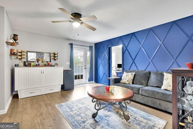 living area with ceiling fan, dark wood-type flooring, and a barn door