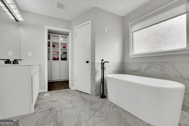 bathroom with shower with separate bathtub and tile walls