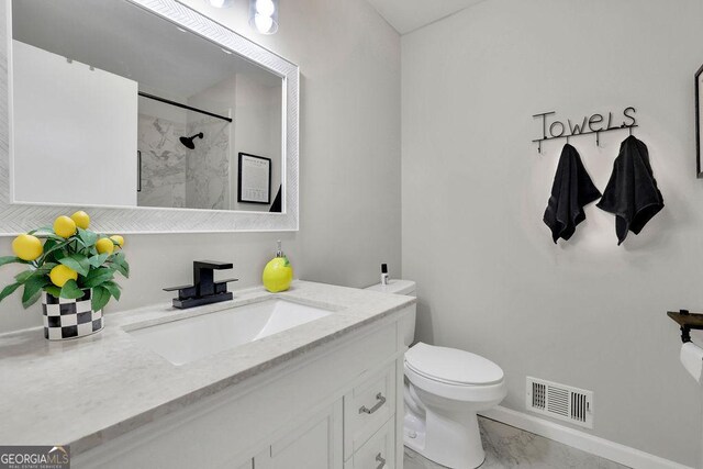 bathroom with tiled shower and vanity