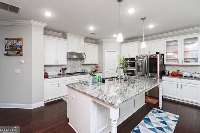 kitchen featuring a center island with sink, hanging light fixtures, sink, light stone countertops, and appliances with stainless steel finishes