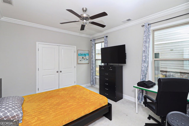 carpeted bedroom with a closet, ceiling fan, and crown molding