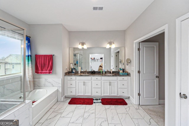 bathroom featuring vanity and independent shower and bath