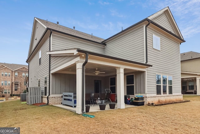 rear view of property with central air condition unit, ceiling fan, and a lawn