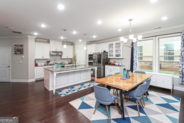 dining area with crown molding, a chandelier, and dark hardwood / wood-style floors